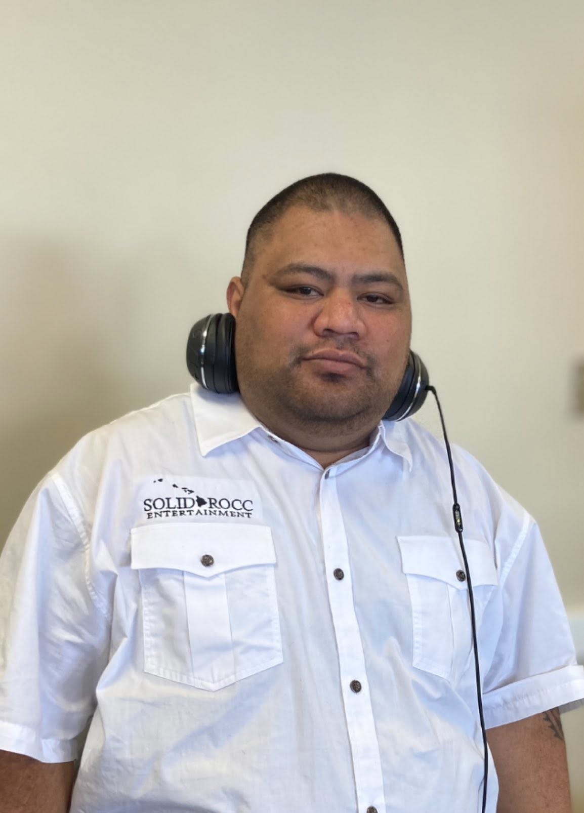 DJ Sio (Siope Kivaha) in a SolidRocc Entertainment shirt with headphones